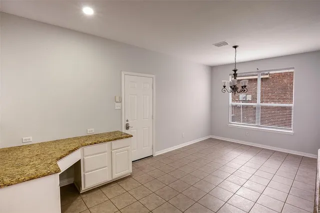 a kitchen with granite countertop white cabinets and white appliances
