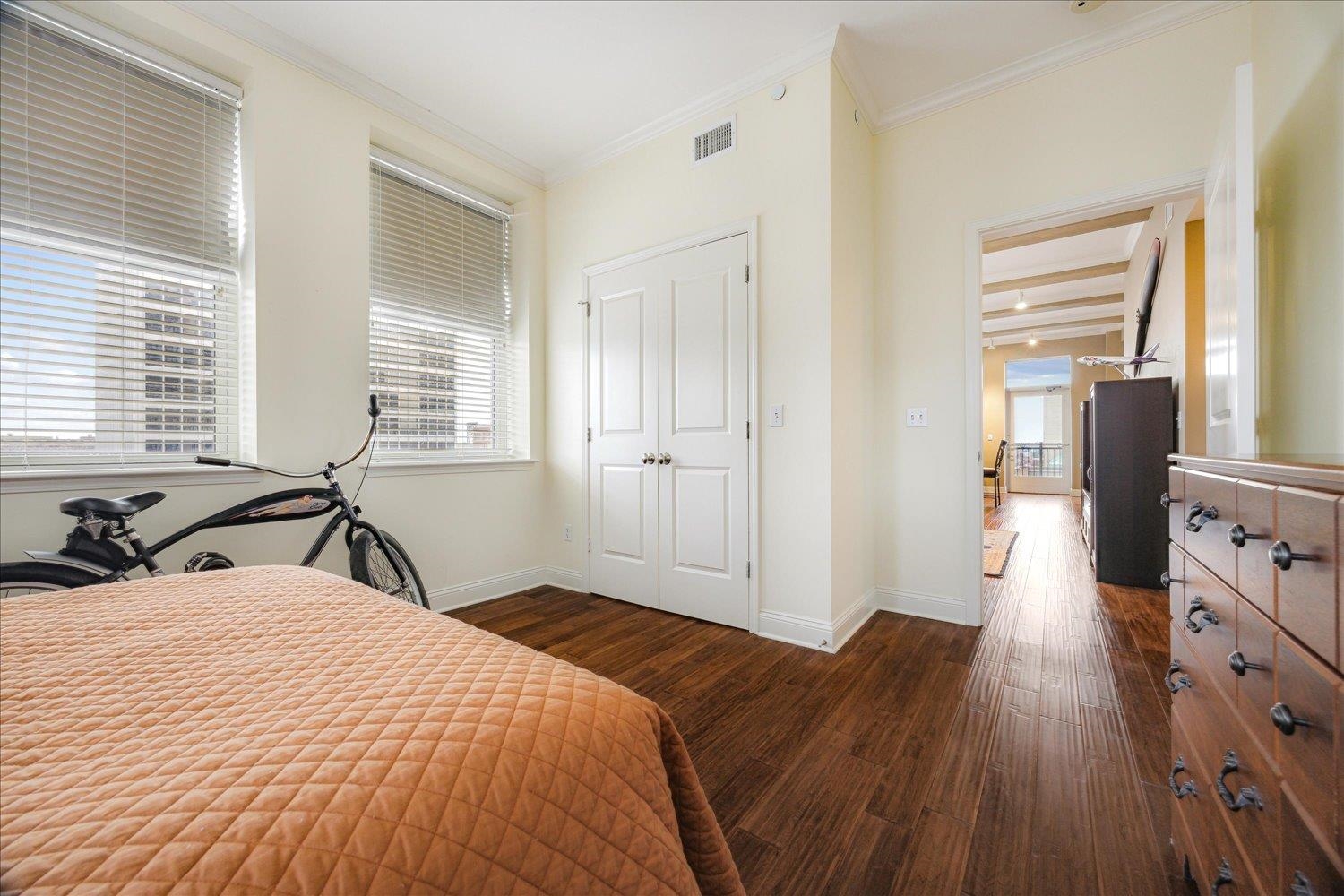 127 Madison Avenue, Unit 602 Memphis, TN 38103 - Photo 18 of 25 Bedroom with dark wood finished floors, multiple windows, and crown molding