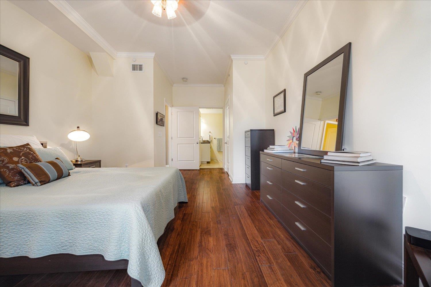 127 Madison Avenue, Unit 602 Memphis, TN 38103 - Photo 22 of 25 a bedroom with a bed and wooden floor