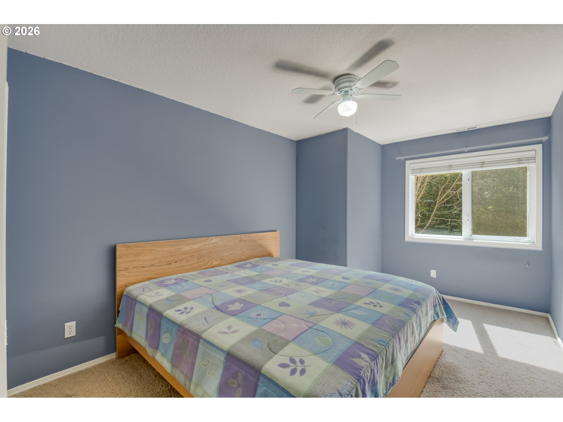 9583 Northwest Randall Lane Portland, OR 97229 - Photo 17 of 41 a bedroom with a large bed and a chandelier