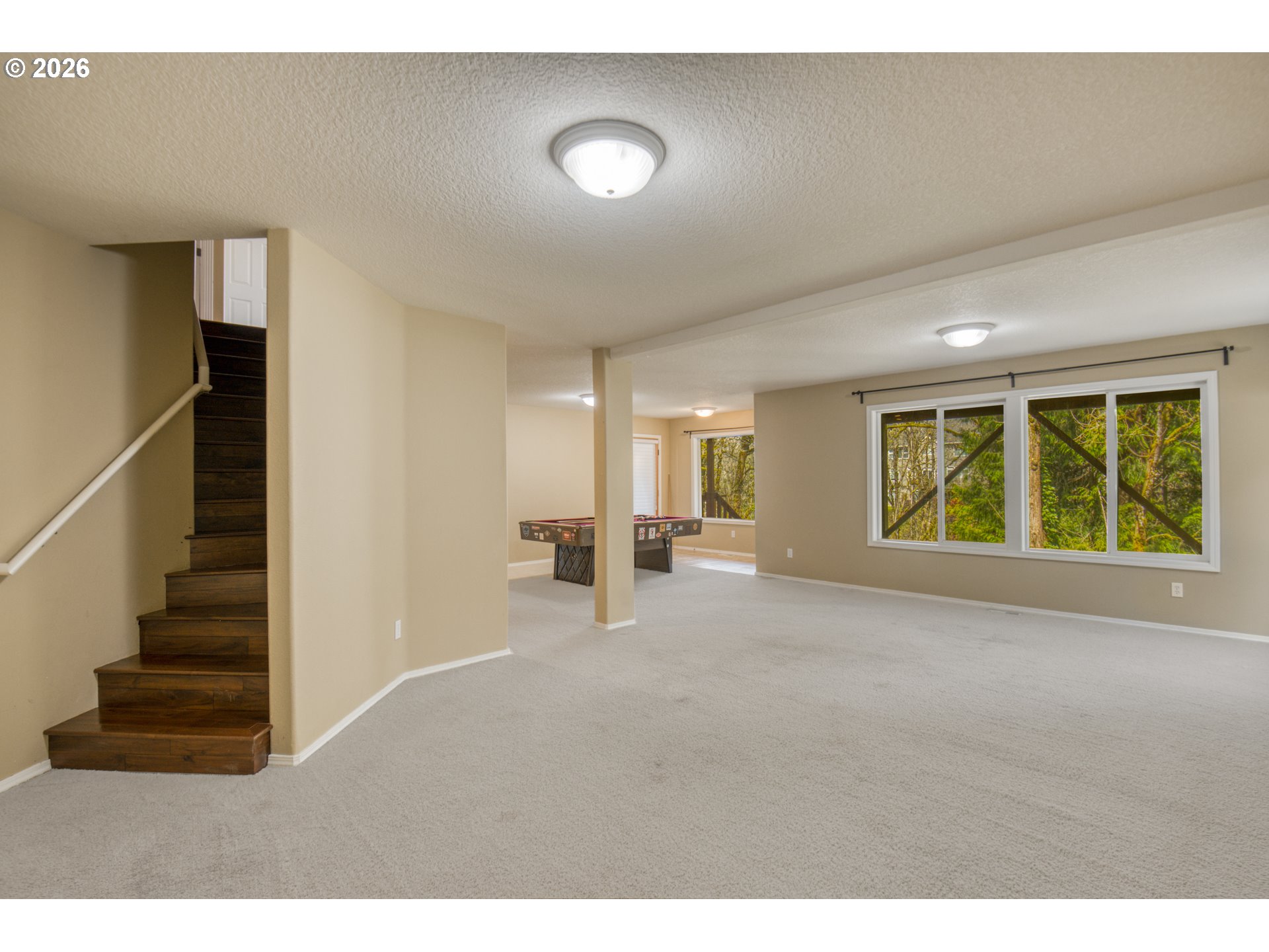 9583 Northwest Randall Lane Portland, OR 97229 - Photo 25 of 41 a view of an empty room with wooden floor and windows