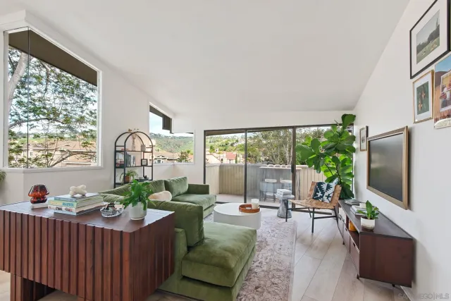 a living room with furniture a flat screen tv and a large window