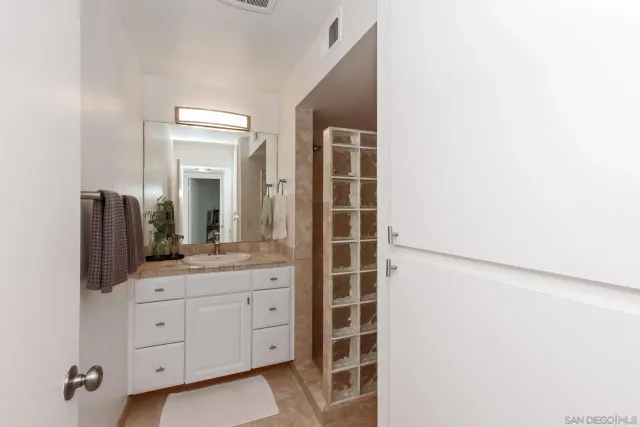 a spacious bathroom with a granite countertop sink and a mirror