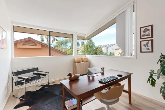 a view of a workspace with furniture and a window