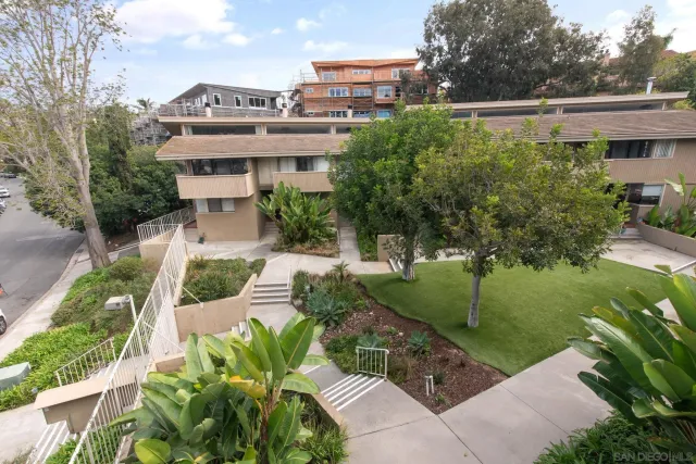 a view of a house with a yard and potted plants