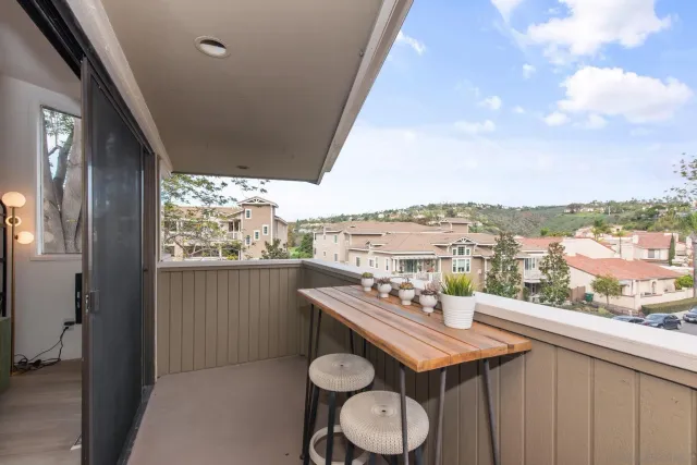 a view of a balcony with furniture and a floor to ceiling window