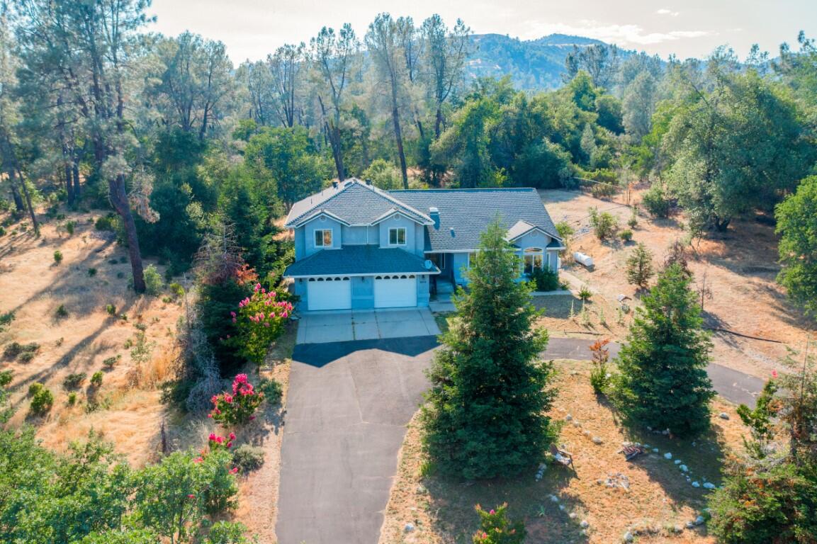 a front view of a house with a yard and mountain view