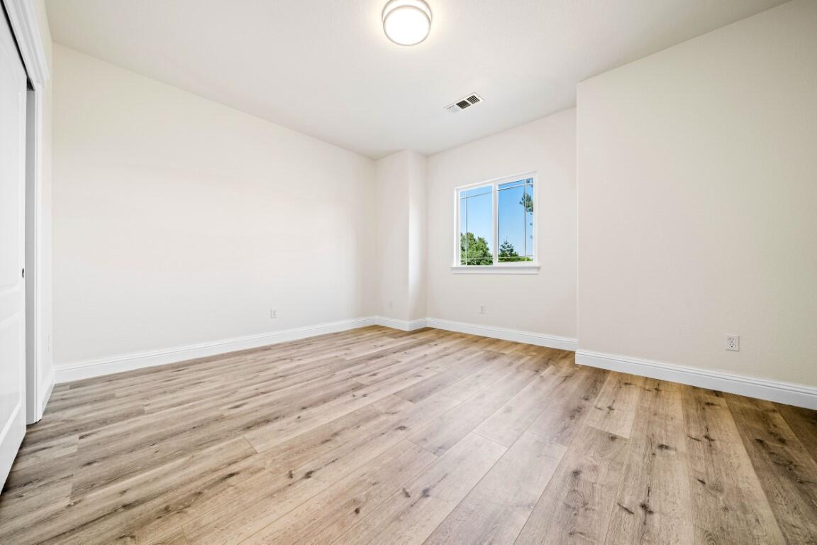 8418 Placer Road Redding, CA 96001 - Photo 3 of 47 an empty room with wooden floor and windows