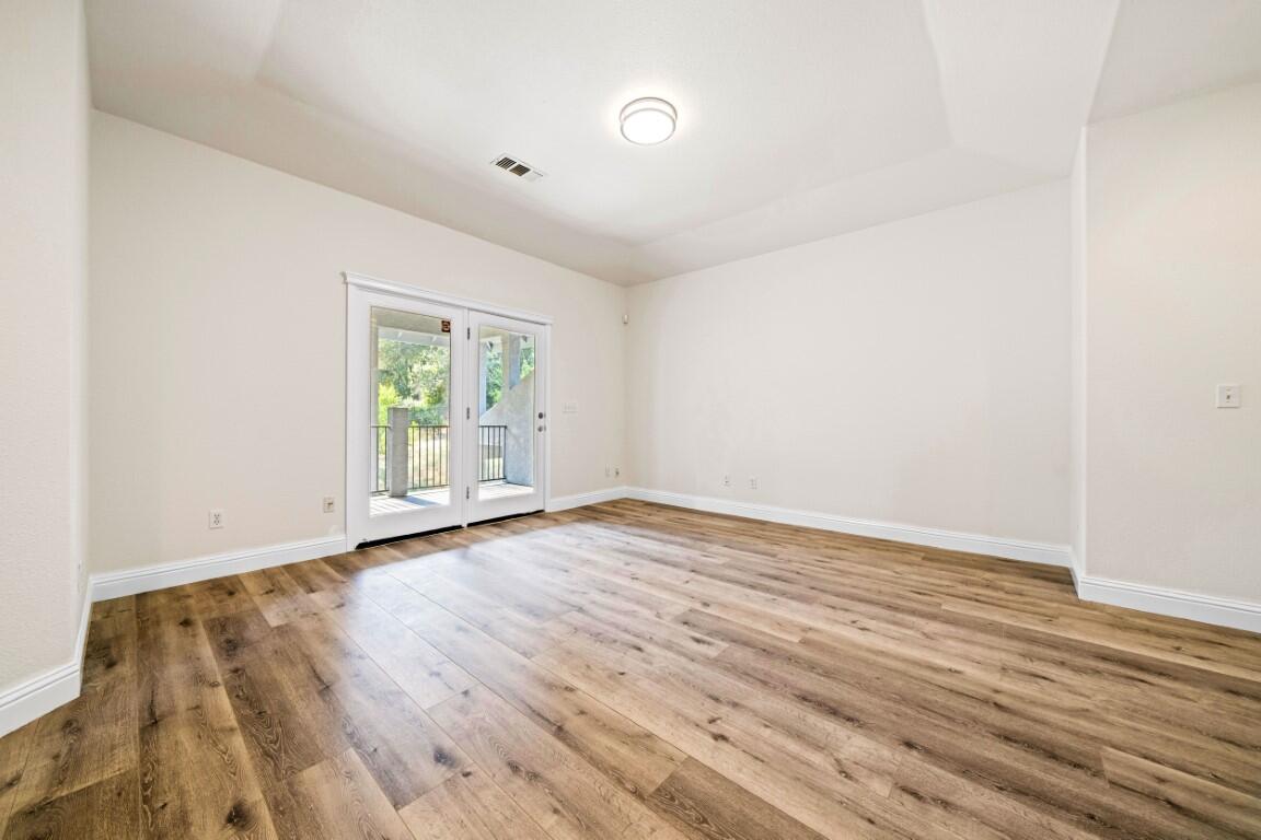8418 Placer Road Redding, CA 96001 - Photo 5 of 47 an empty room with wooden floor and windows
