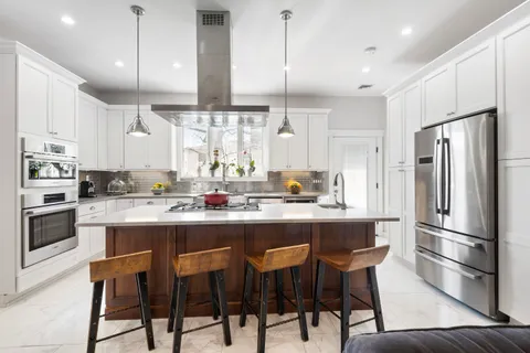a kitchen with refrigerator a sink and chairs