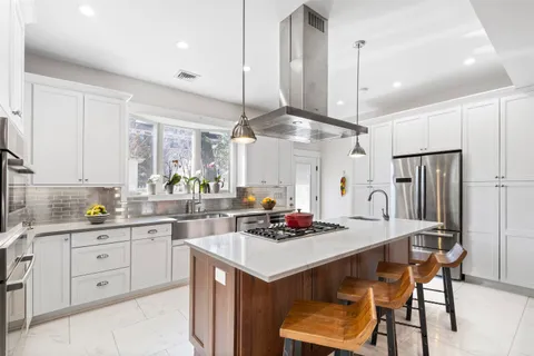 a kitchen with stainless steel appliances a sink stove and cabinets