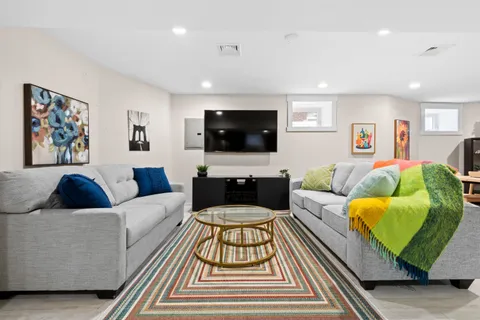 a living room with furniture a rug and kitchen view