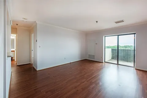 an empty room with wooden floor and sliding door
