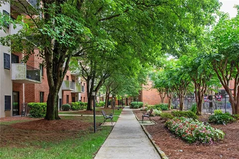a front view of a house with a garden and trees