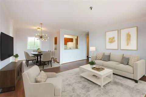 a living room with furniture a large window and a flat screen tv