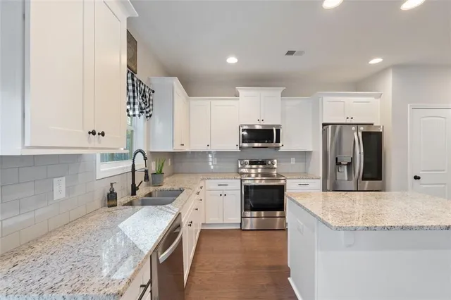 a view of an empty room with wooden floor fireplace and a window