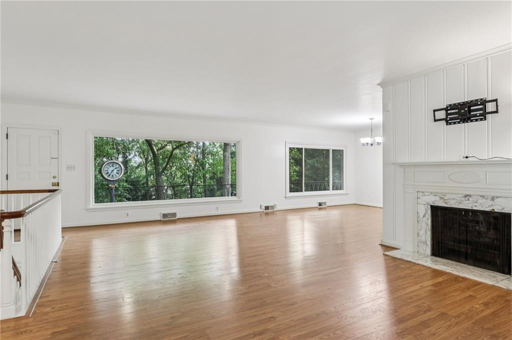 806 Belmont Road Butler, PA 16001 - Photo 16 of 49 an empty room with wooden floor fireplace and windows