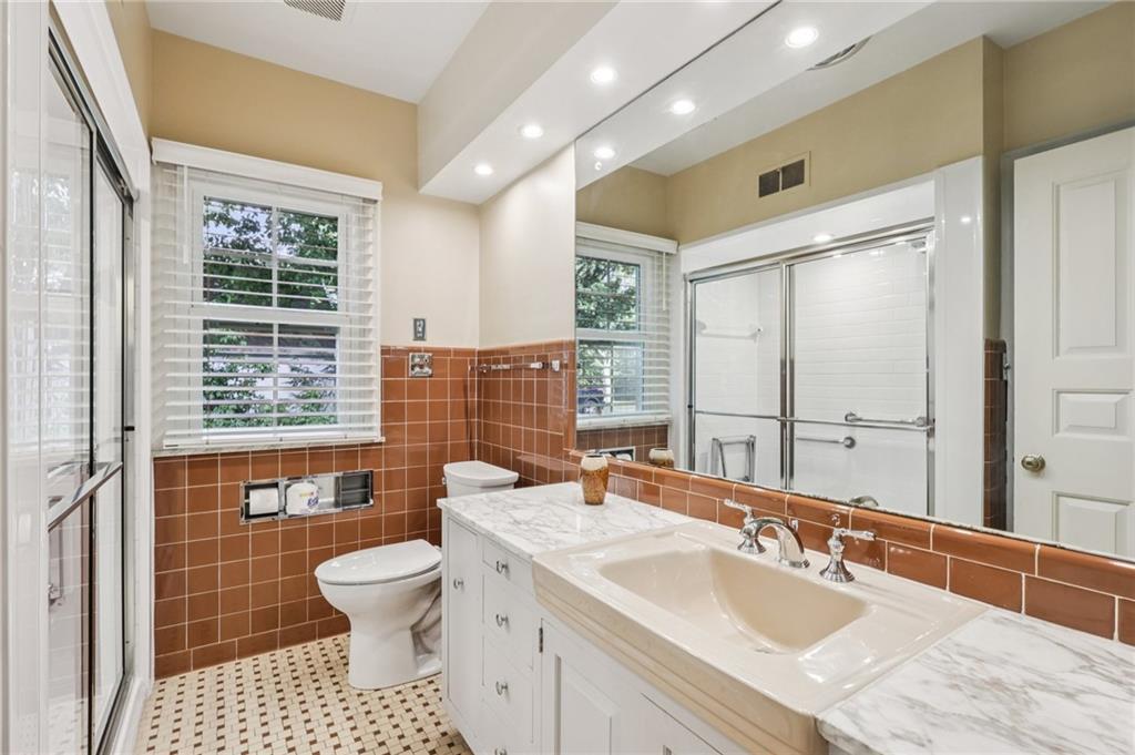 806 Belmont Road Butler, PA 16001 - Photo 28 of 49 a bathroom with a sink a toilet a large mirror and a shower