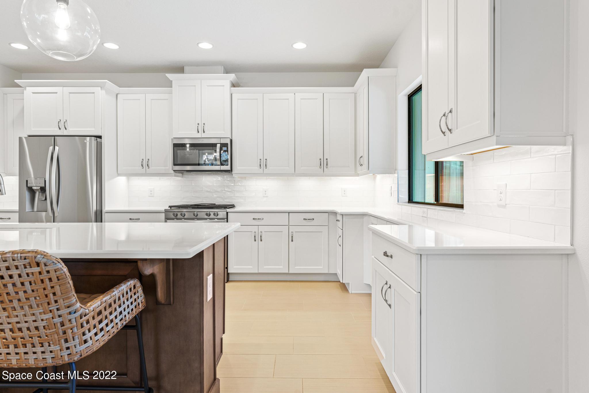 3231 Casterton Drive Melbourne, FL 32940 - Photo 16 of 88 a kitchen with stainless steel appliances granite countertop a stove a sink a refrigerator and white cabinets