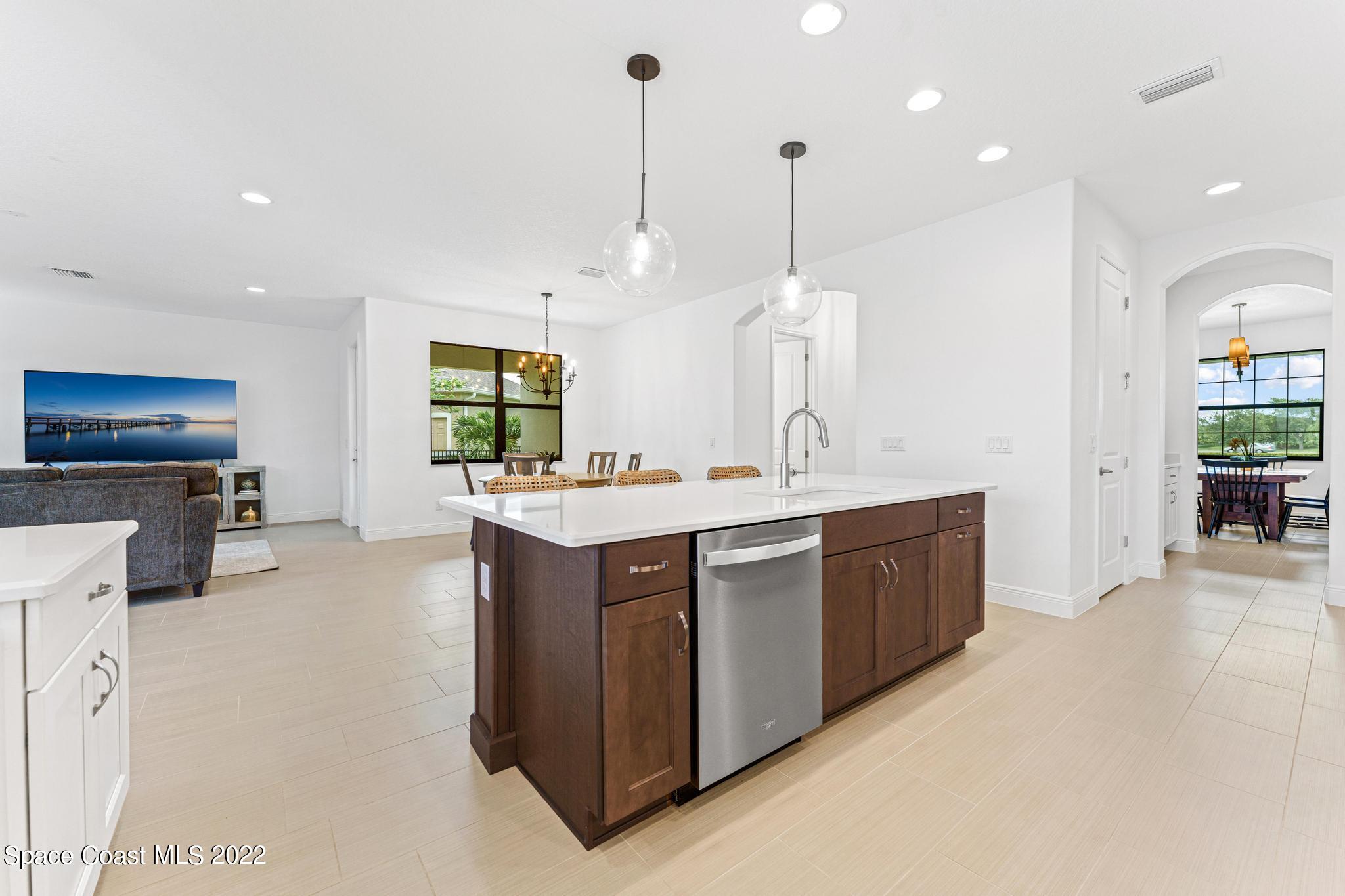 3231 Casterton Drive Melbourne, FL 32940 - Photo 19 of 88 a kitchen with stainless steel appliances granite countertop a sink a stove and a wooden floor