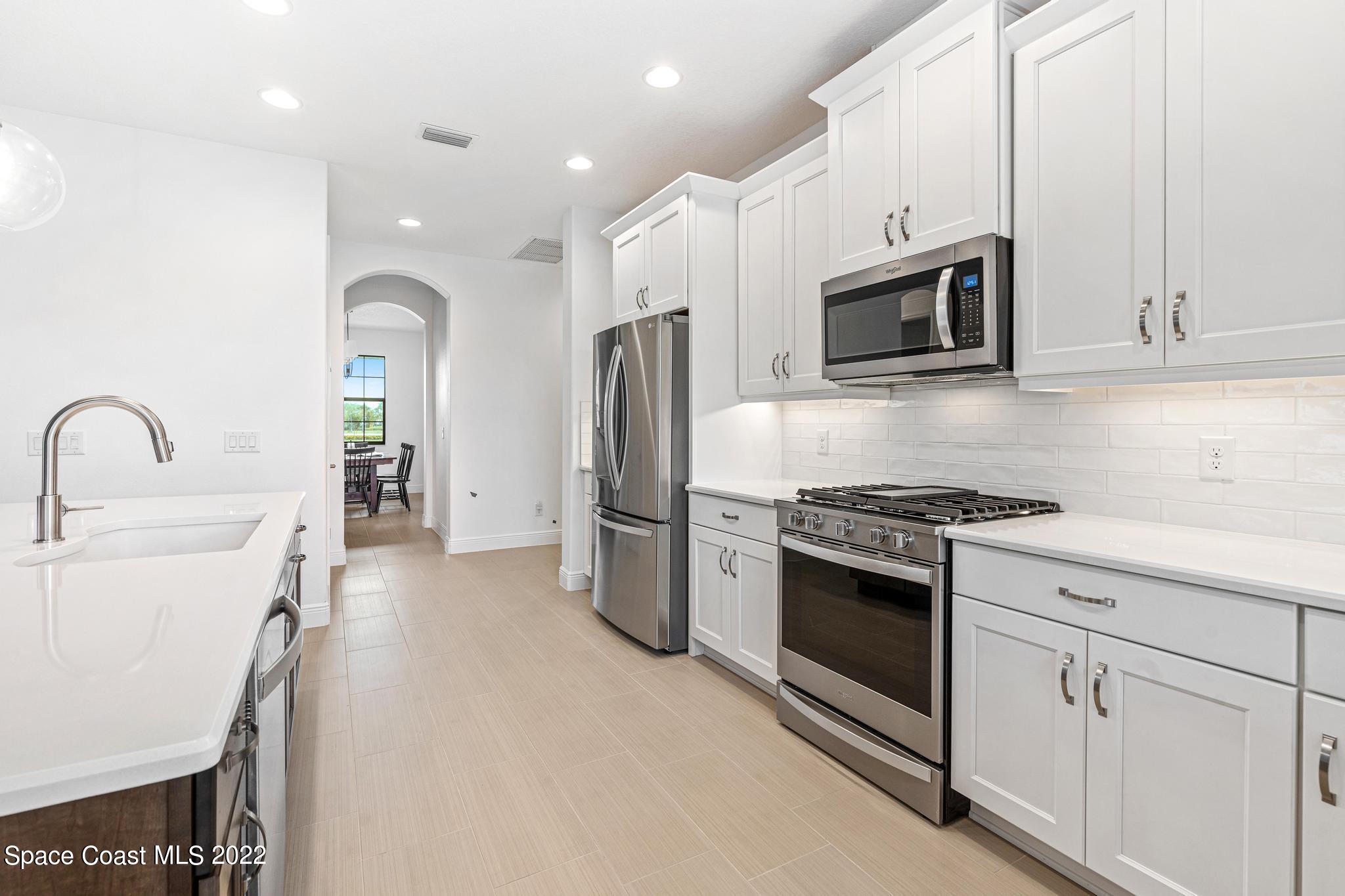 3231 Casterton Drive Melbourne, FL 32940 - Photo 21 of 88 a kitchen with stainless steel appliances a stove microwave and sink