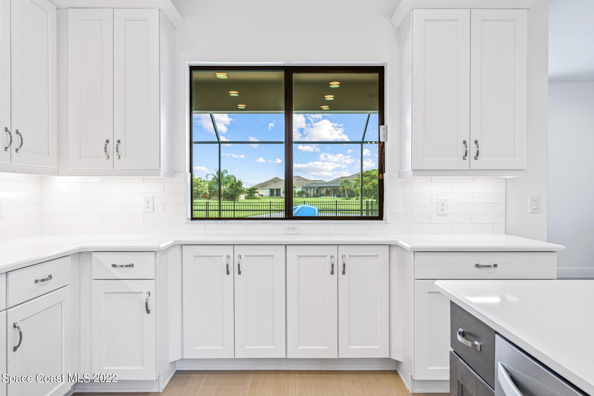 3231 Casterton Drive Melbourne, FL 32940 - Photo 25 of 88 a kitchen with white cabinets and a window