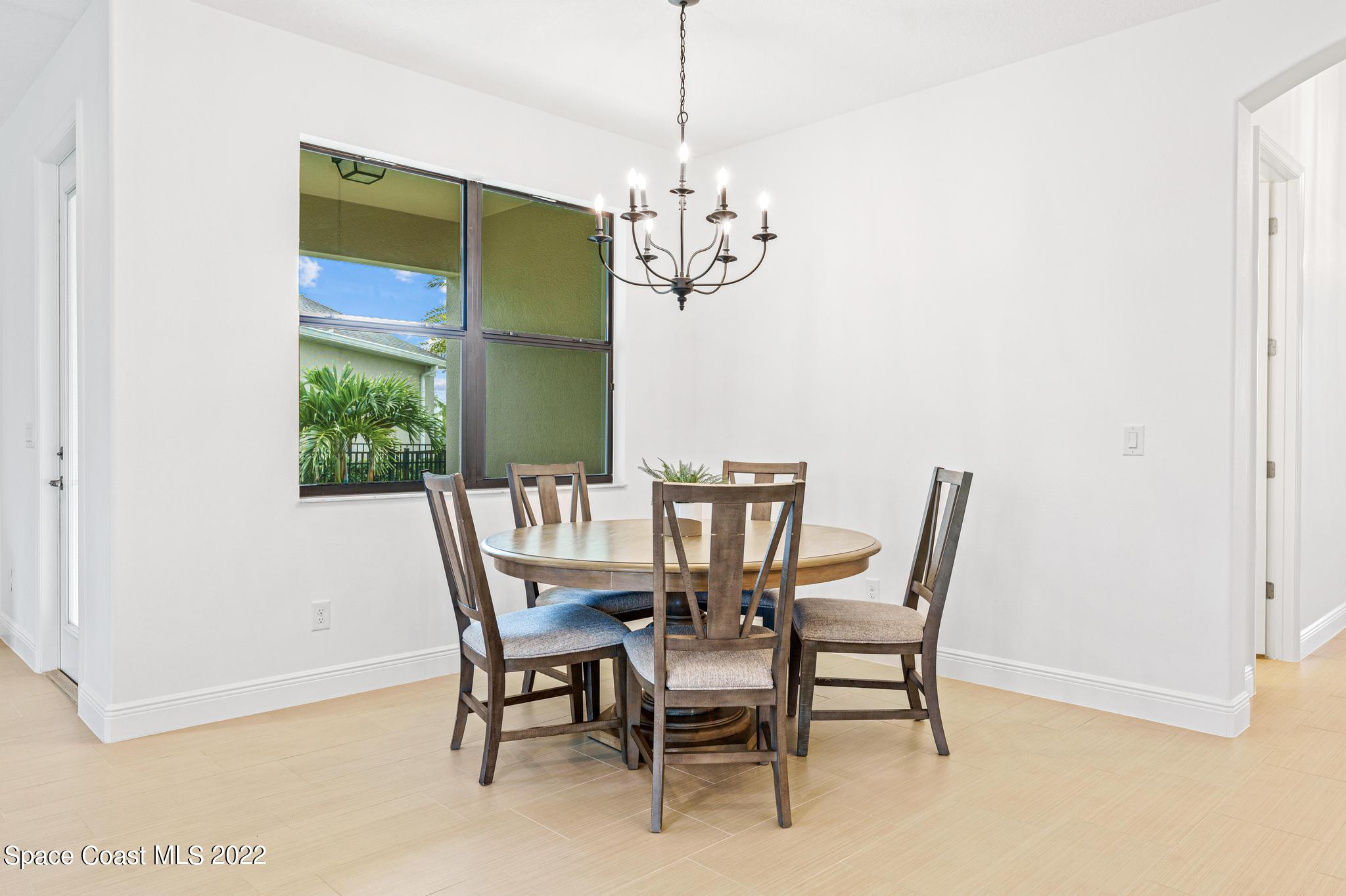3231 Casterton Drive Melbourne, FL 32940 - Photo 29 of 88 a dining room with furniture a chandelier and window