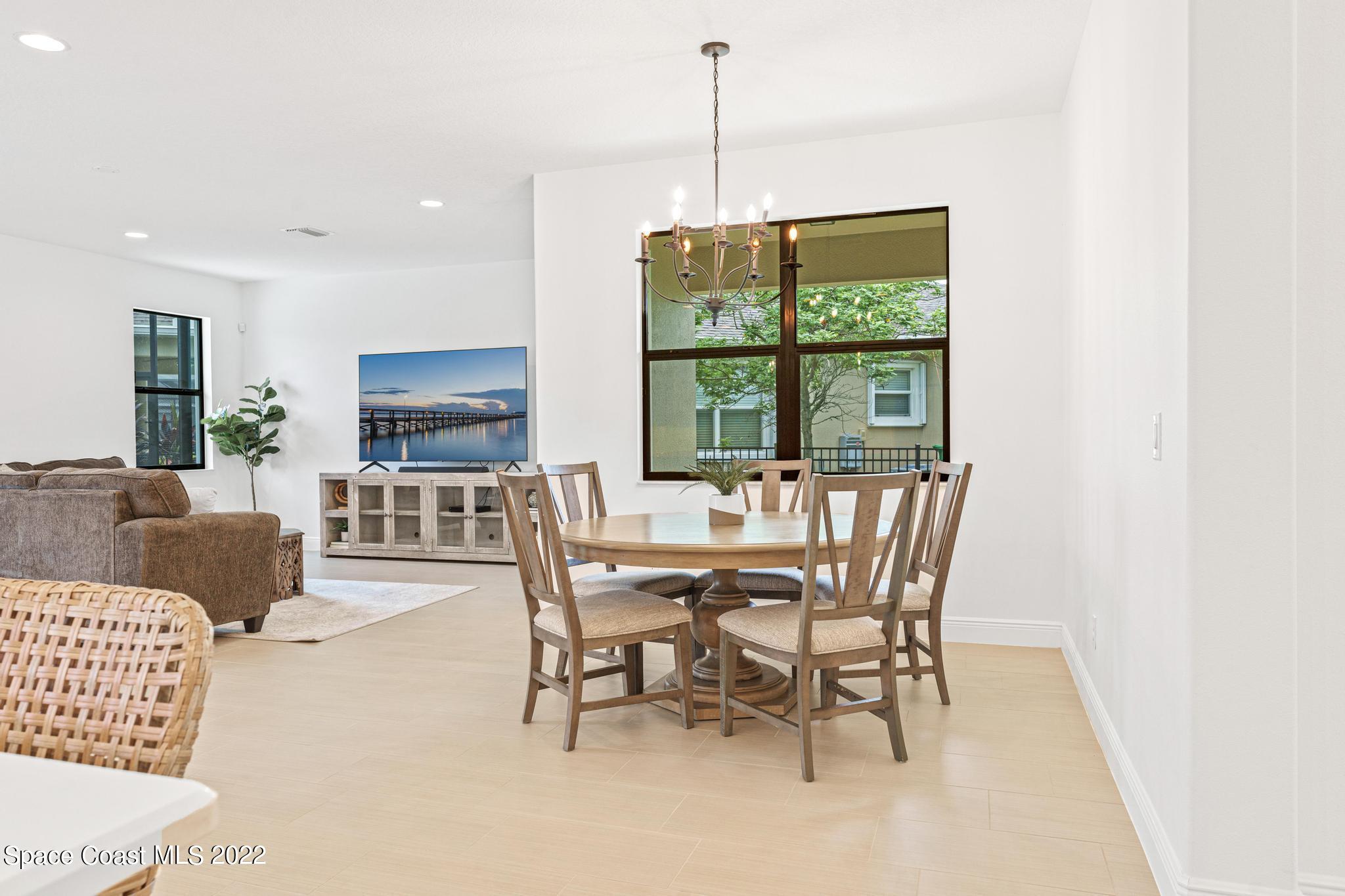 3231 Casterton Drive Melbourne, FL 32940 - Photo 30 of 88 a dining room with furniture a chandelier and window