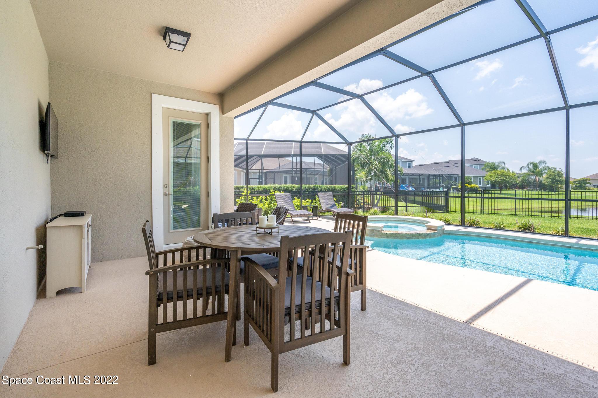 3231 Casterton Drive Melbourne, FL 32940 - Photo 63 of 88 a dining room with furniture and a floor to ceiling window
