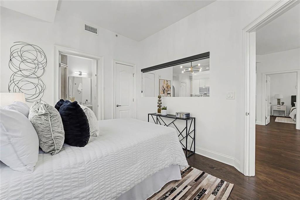 2828 Peachtree Road Northwest, Unit 1704 Atlanta, GA 30305 - Photo 16 of 41 a bedroom with a bed and wooden floor