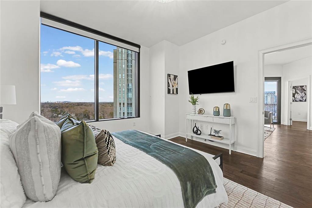 2828 Peachtree Road Northwest, Unit 1704 Atlanta, GA 30305 - Photo 20 of 41 a bedroom with a bed a television and wooden floor