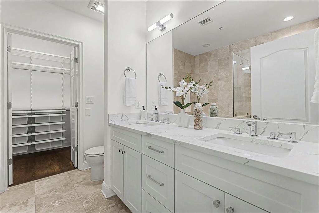 2828 Peachtree Road Northwest, Unit 1704 Atlanta, GA 30305 - Photo 21 of 41 a bathroom with a double vanity sink a mirror and a bathtub