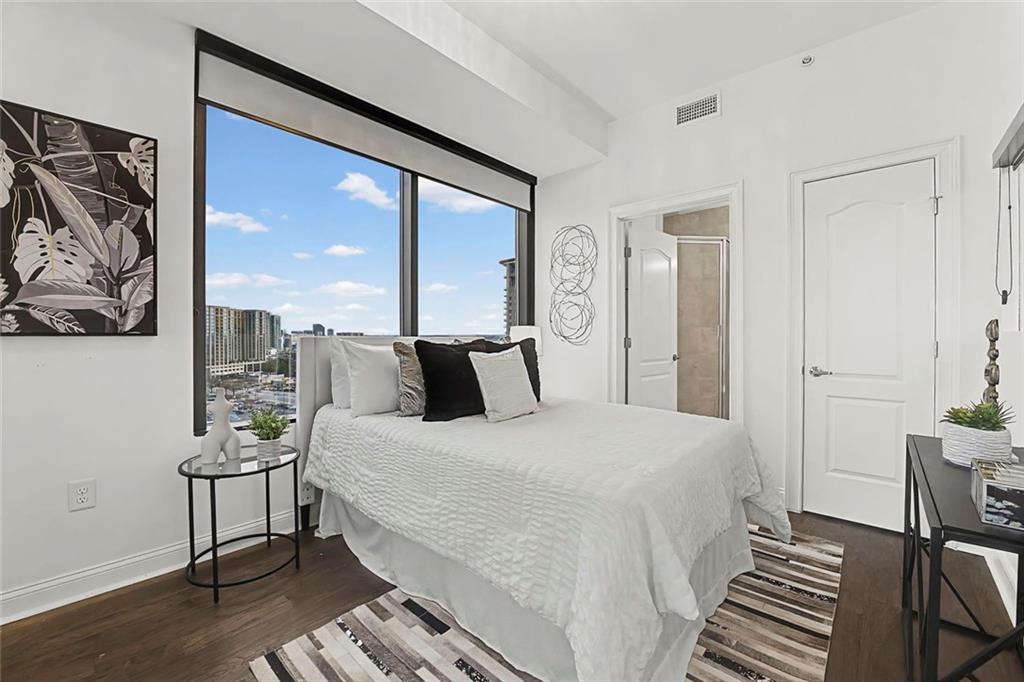 2828 Peachtree Road Northwest, Unit 1704 Atlanta, GA 30305 - Photo 32 of 41 a bedroom with a bed and wooden floor