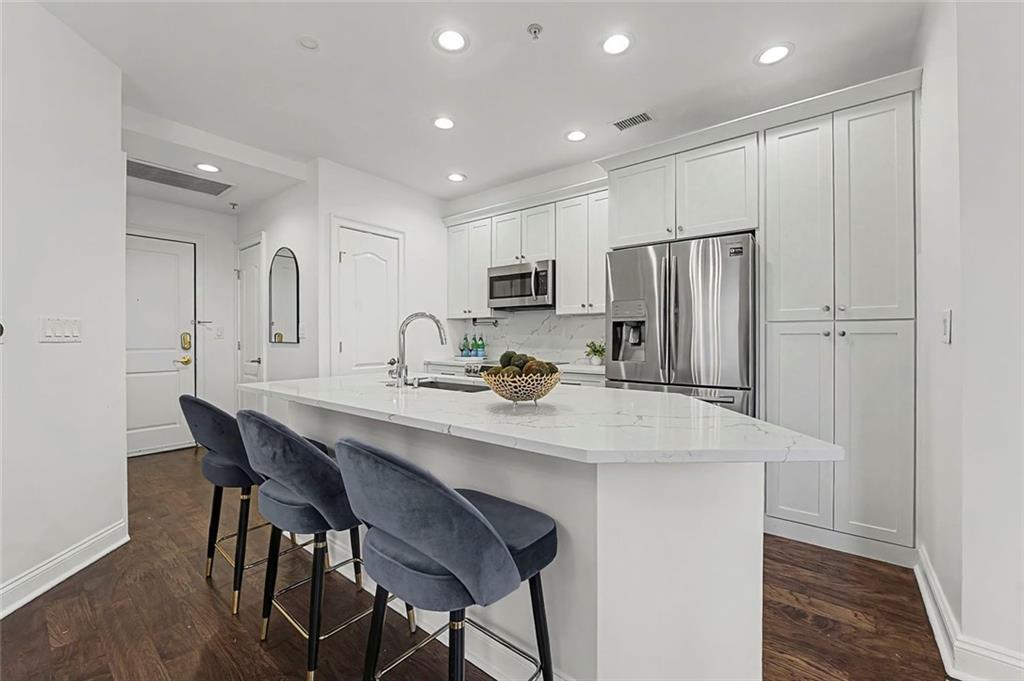 2828 Peachtree Road Northwest, Unit 1704 Atlanta, GA 30305 - Photo 4 of 41 a kitchen with refrigerator and chairs
