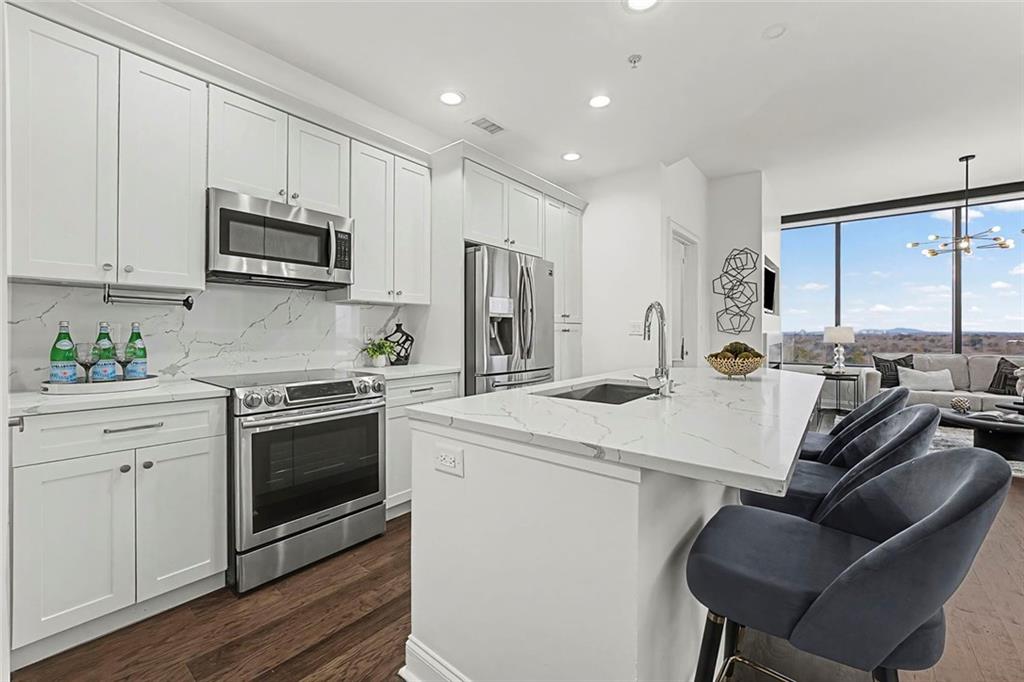 2828 Peachtree Road Northwest, Unit 1704 Atlanta, GA 30305 - Photo 5 of 41 a kitchen with stainless steel appliances granite countertop a stove a sink dishwasher and a refrigerator with wooden floor