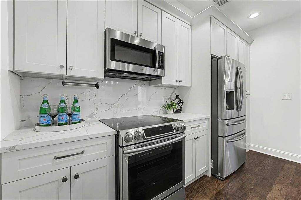 2828 Peachtree Road Northwest, Unit 1704 Atlanta, GA 30305 - Photo 6 of 41 a kitchen with stainless steel appliances white cabinets and a stove top oven