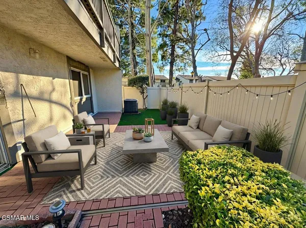 a view of a patio with couches table and chairs and potted plants
