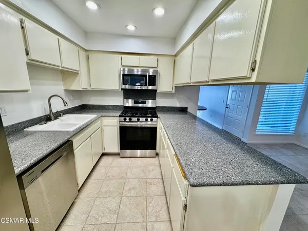 a kitchen with stainless steel appliances granite countertop a sink stove and cabinets
