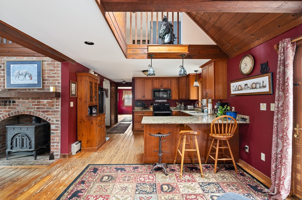 168 Brickyard Road Southampton, MA 01073 - Photo 13 of 42 a kitchen with stainless steel appliances granite countertop a stove a sink and a dining table with wooden floor
