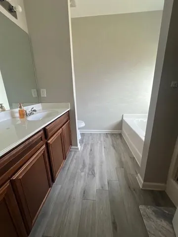 an empty room with wooden floor ceiling fan and window