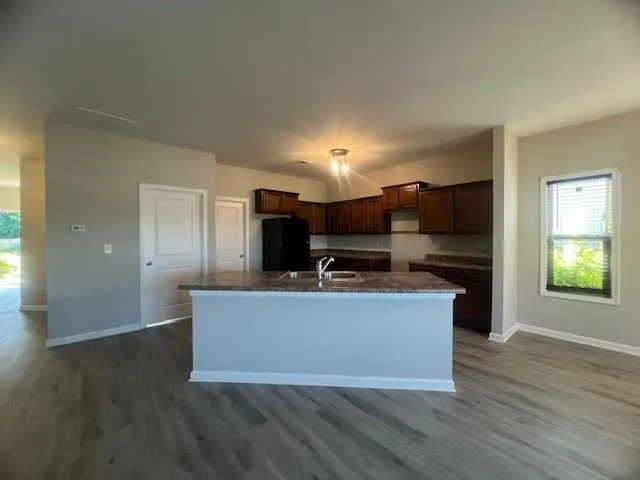 a view of kitchen with microwave stove refrigerator and cabinets