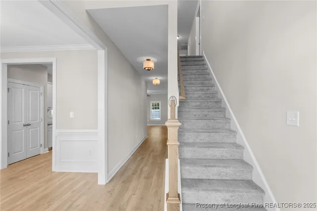a view of a hallway with wooden floor and staircase