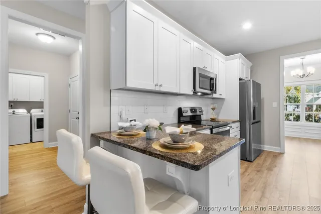 a kitchen with stainless steel appliances granite countertop a sink stove refrigerator and cabinets