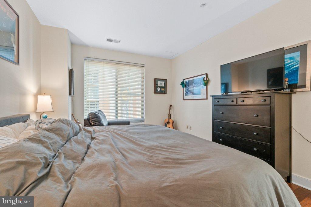 675 President Street, Unit 1404 Baltimore, MD 21202 - Photo 11 of 31 a bedroom with a bed and a flat screen tv