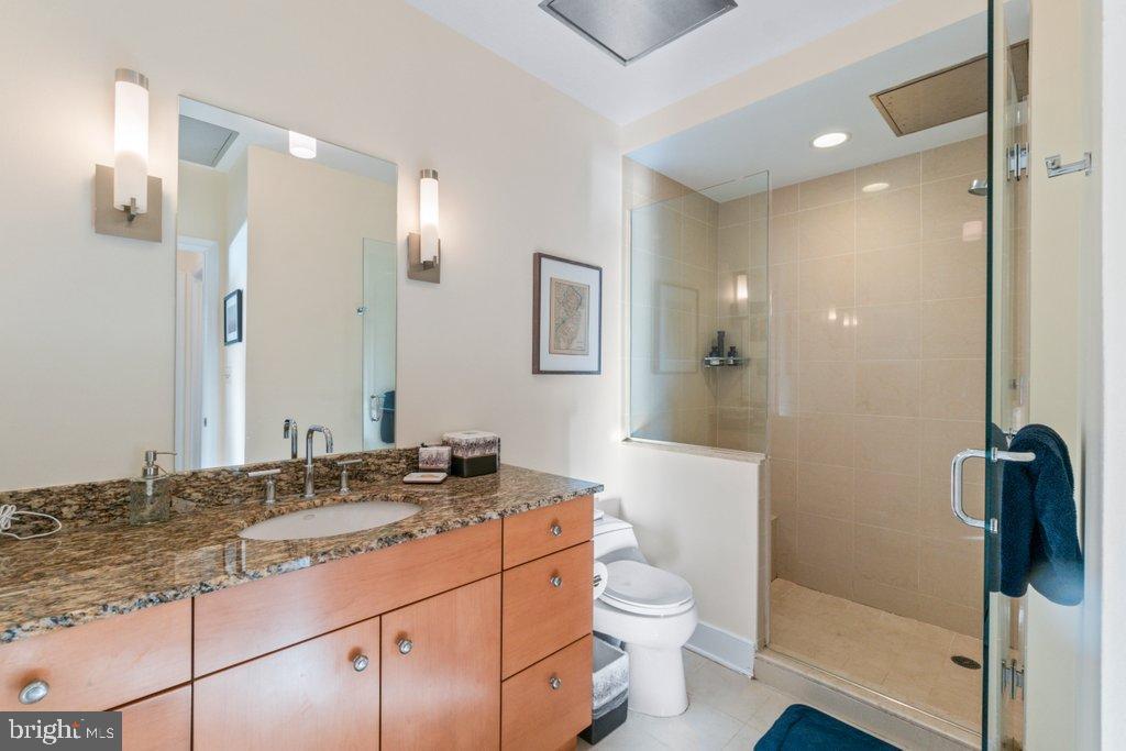 675 President Street, Unit 1404 Baltimore, MD 21202 - Photo 14 of 31 a bathroom with a granite countertop sink toilet and shower