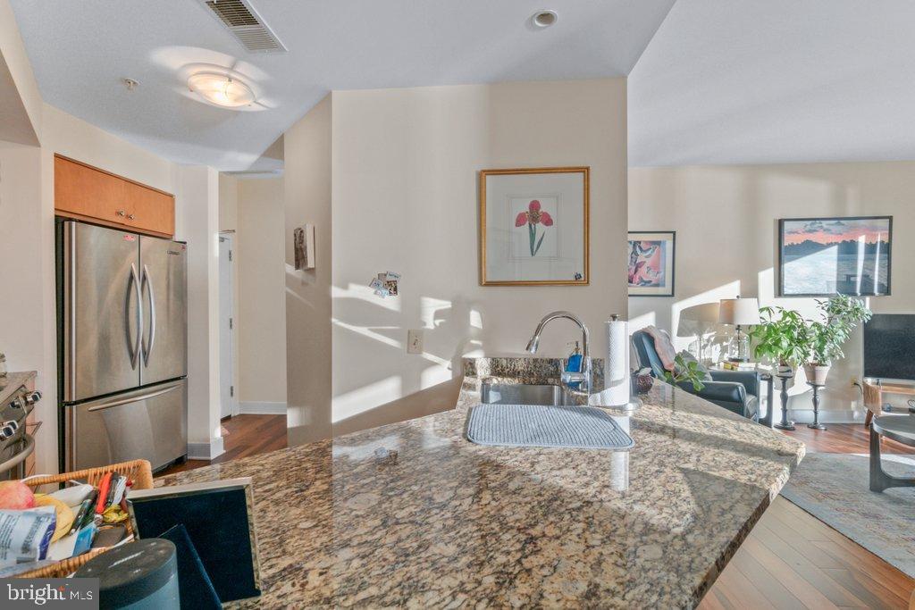 675 President Street, Unit 1404 Baltimore, MD 21202 - Photo 24 of 31 a kitchen with granite countertop a refrigerator and a stove top oven