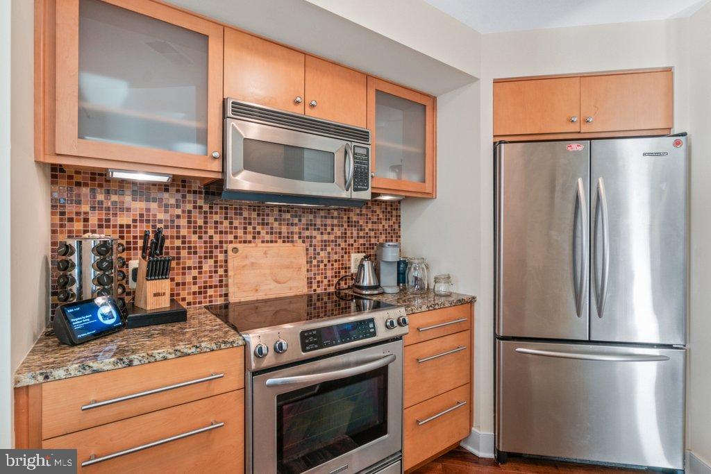 675 President Street, Unit 1404 Baltimore, MD 21202 - Photo 27 of 31 a kitchen with appliances a refrigerator and cabinets