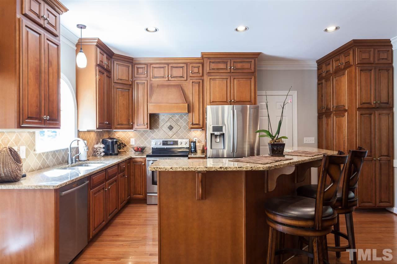 2613 Lizei Street Raleigh, NC 27616 - Photo 3 of 25 a kitchen with stainless steel appliances granite countertop sink a window and chairs