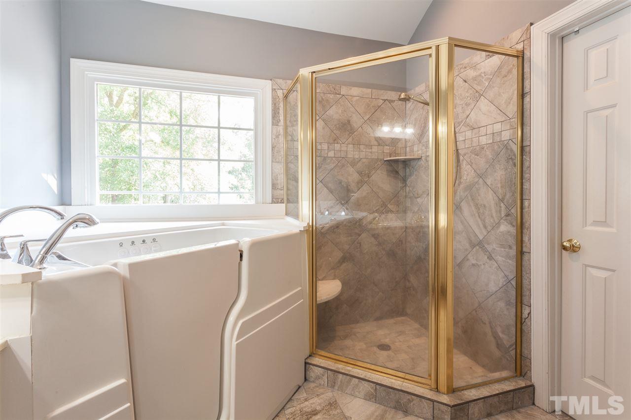 2613 Lizei Street Raleigh, NC 27616 - Photo 21 of 25 a bathroom with a shower and a sink a mirror