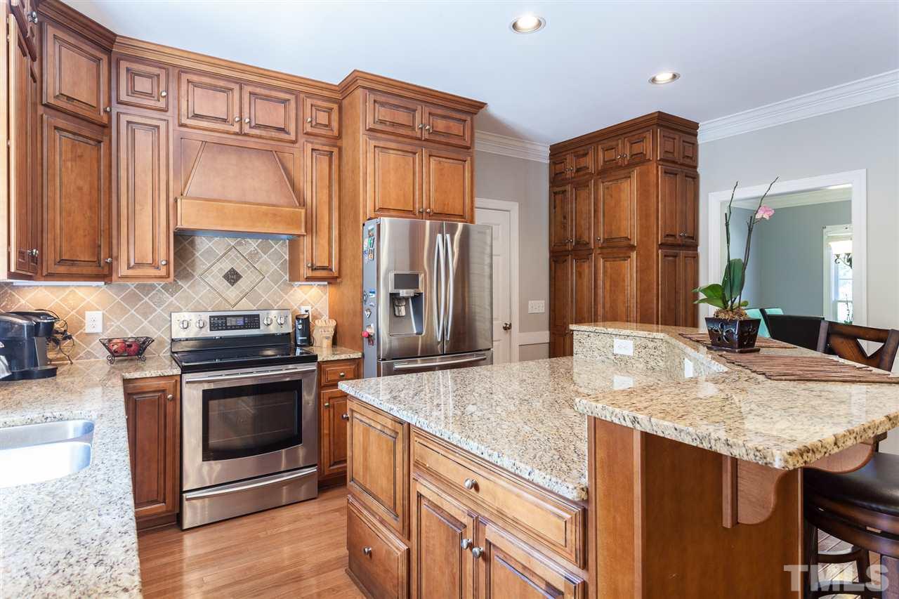 2613 Lizei Street Raleigh, NC 27616 - Photo 6 of 25 a kitchen with stainless steel appliances granite countertop a stove a sink and a refrigerator